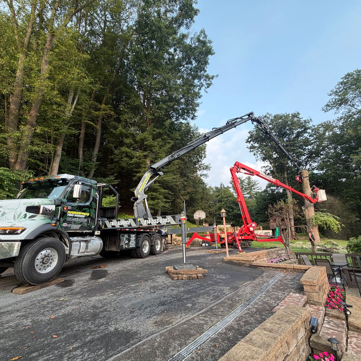 Arbor Pro&rsquo;s crane truck and spider lift set up on a residential driveway